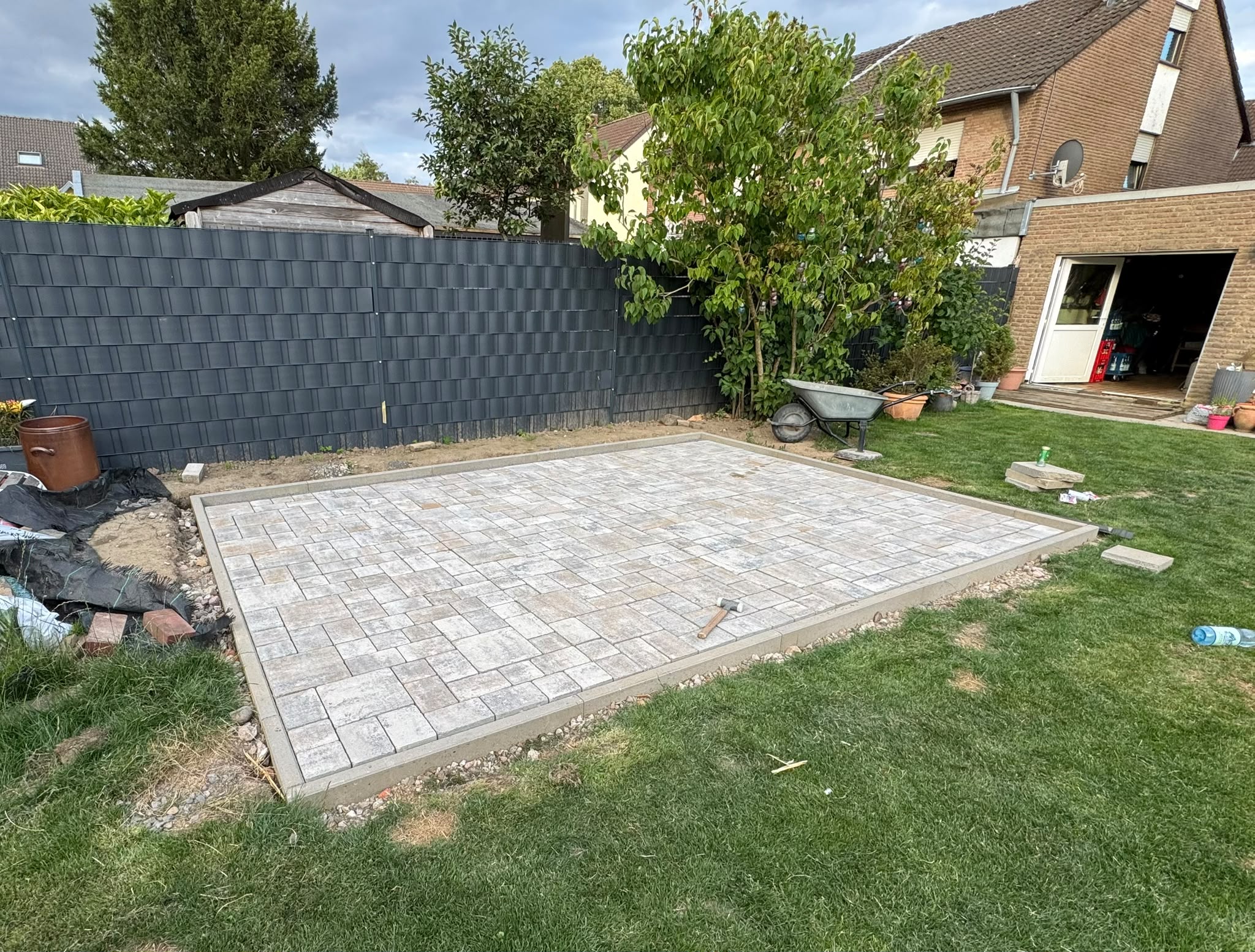 Neu verlegte helle Pflasterfläche in einem Gartenbereich