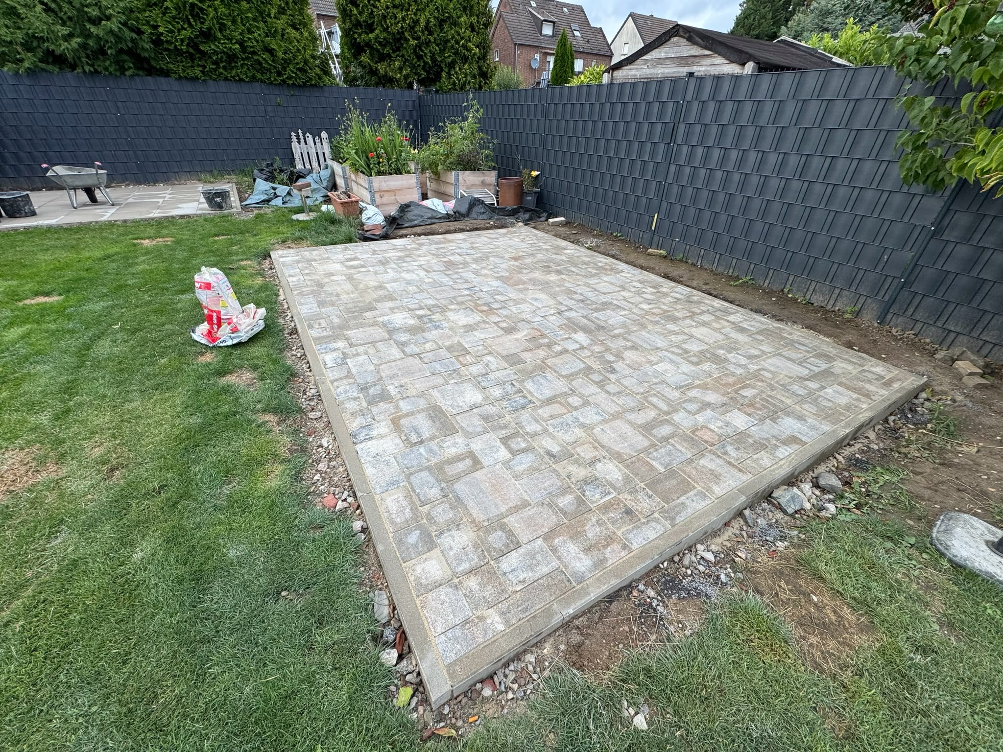 Fertiggestellte Pflasterfläche mit Einfassung und gepflegtem Gartenumfeld